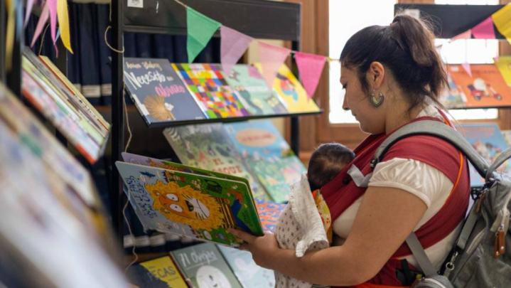 Imagen de bebe con su mama tomando libro