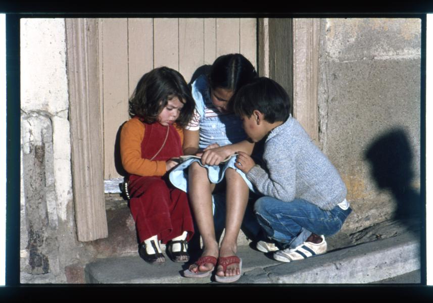 Niños haciendo tareas escolares en la puerta de su casa / Cerro Cordillera